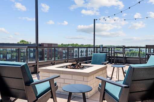 A patio with chairs and a fire pit.
