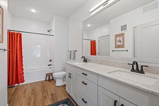 A bathroom with a white sink and a white toilet.