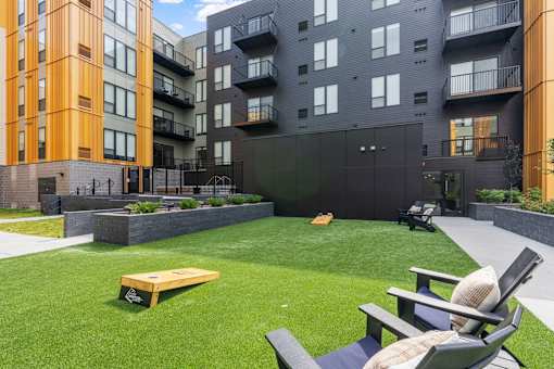 A modern outdoor seating area with a bench and chairs.
