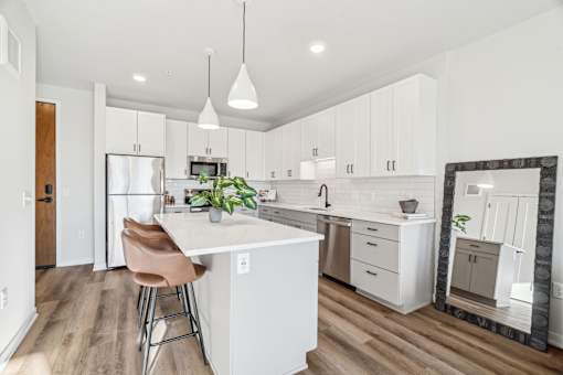 A kitchen with a white island and a refrigerator.