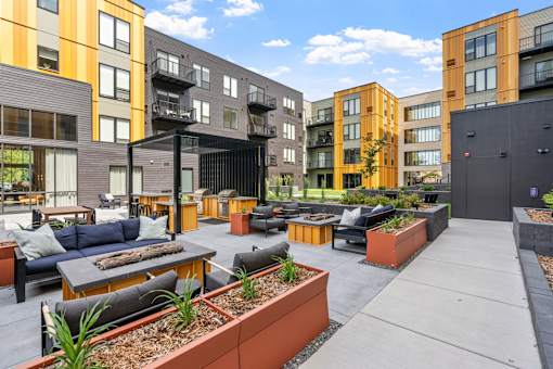 A patio area with a black table and chairs in front of a building.