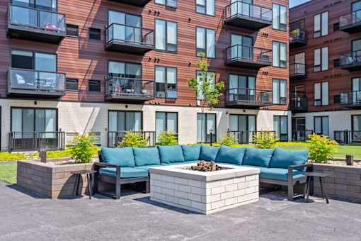 A modern apartment complex with a courtyard and seating area.