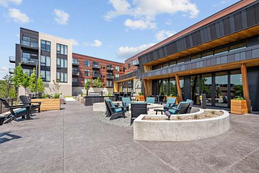A courtyard with a fountain and seating area between two buildings.