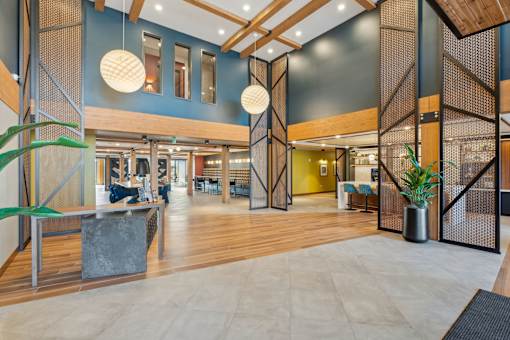 A modern interior with wooden floors and a mix of seating areas.