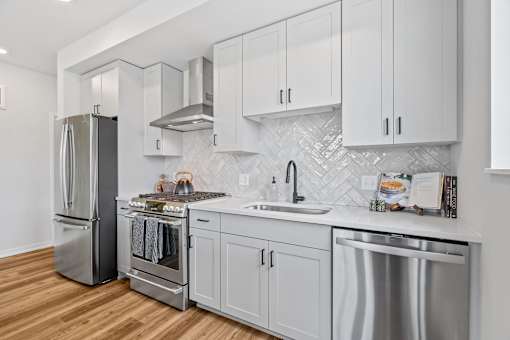 a kitchen with white cabinets and stainless steel appliances