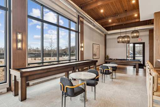 A room with a long table and chairs with a view of the outside.