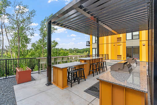 A yellow and grey outdoor bar area with a black railing.
