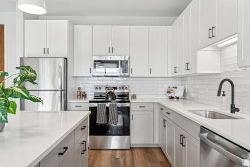 A modern kitchen with white cabinets and stainless steel appliances.