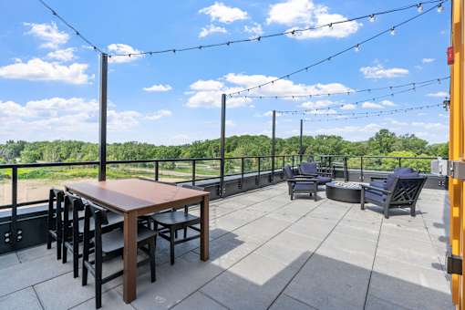 A patio with a table and chairs is set up on a balcony.