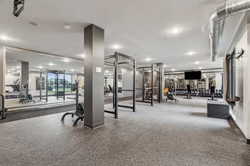 A gym with a variety of equipment including treadmills, weights, and exercise machines.