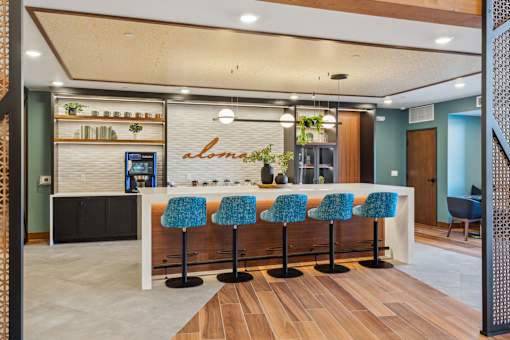A bar area with blue chairs and a counter.
