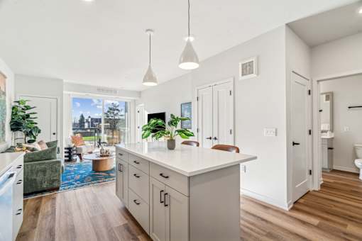 A kitchen with a large island and pendant lights.