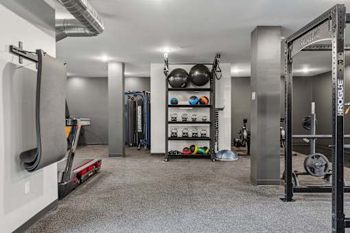 A gym with a variety of equipment including weights and a treadmill.