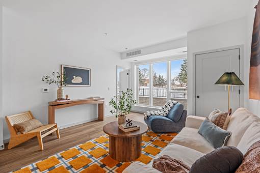 A living room with a white couch and a wooden coffee table.