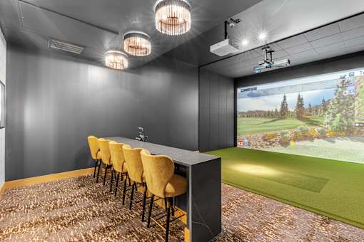 A room with a long table and chairs with a screen at the end of the table.