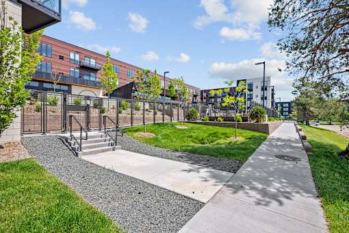 A walkway with a metal fence and steps leading to a building.