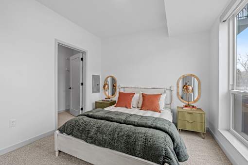 A bedroom with a bed, nightstand, and two round mirrors.
