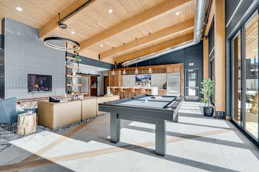 A modern living room with a pool table and a television.