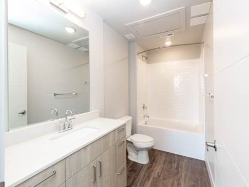 Bathroom with dark wood floors at Soleil Lofts