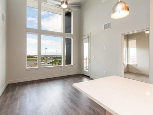 A room with a large window overlooking a field.