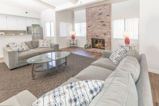 Clubhouse Lounge sitting area with a couch, three chairs, coffee table, large rug and decor at Bent Tree Apartments, Sacramento, CA