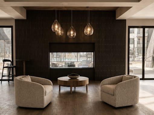 A living room with a fireplace, two chairs and a coffee table.