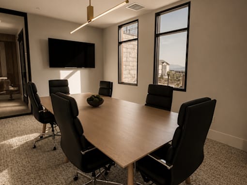 A conference room with a large table and chairs.