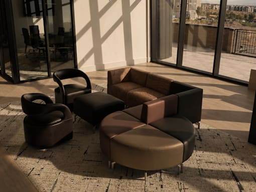 A living room with a brown couch, ottoman, and chair.