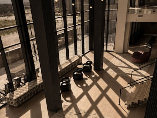 A view of a room with a lot of windows and a few objects on the floor.