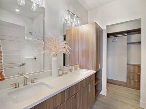 A bathroom with a white sink and gold faucets.