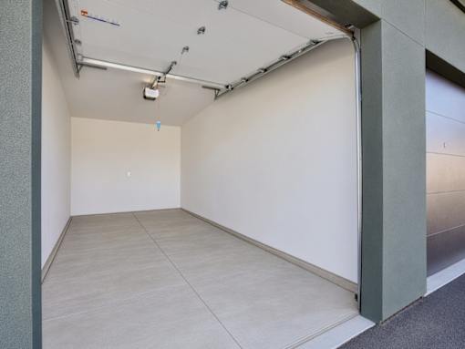 A room with a white wall and a grey floor.