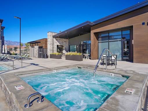 A hot tub sits in front of a modern building.