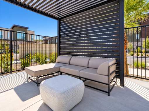 A patio with a white couch and ottoman.