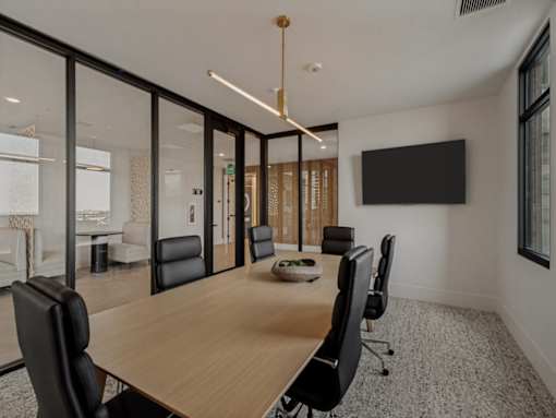 A conference room with a long table and chairs.