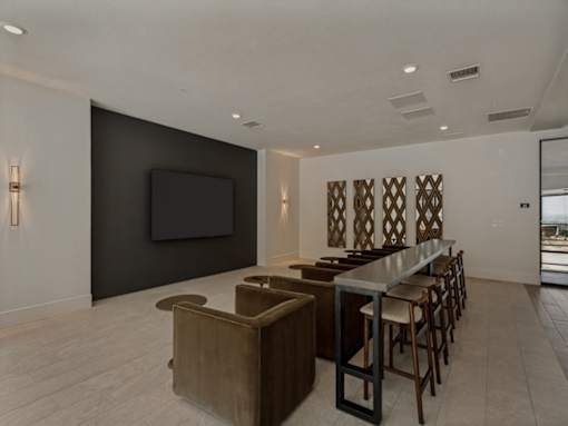 A modern living room with a bar area and a television.