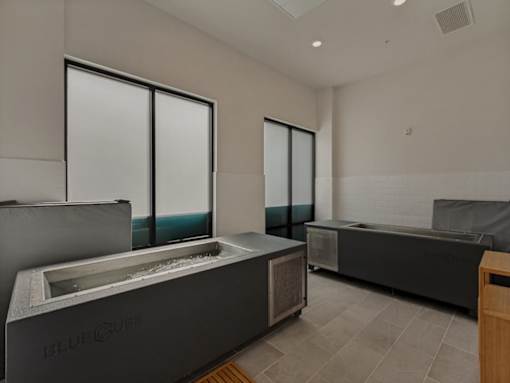 A modern room with a large window and a hot tub.