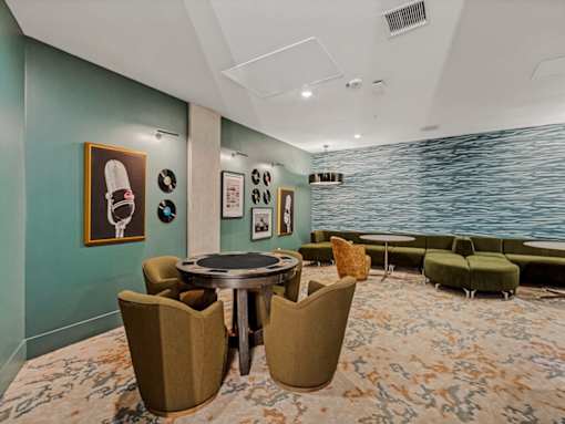 A room with a round table and chairs with a carpet on the floor.