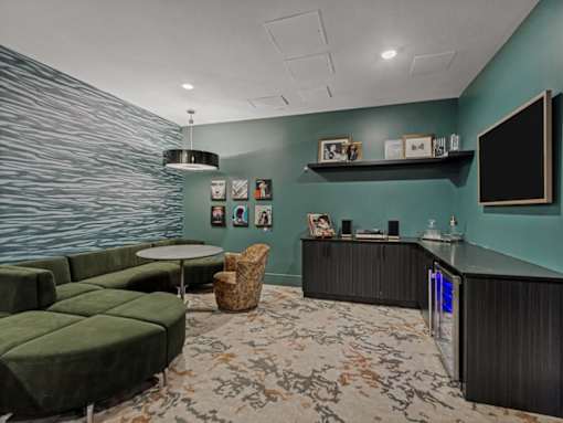 Speakeasy community room with couches and mini fridge