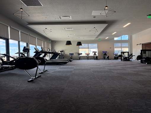 A spacious room with exercise equipment and large windows.