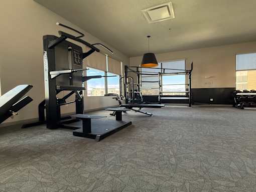 A spacious gym with a variety of equipment including a squat rack, bench, and weights.