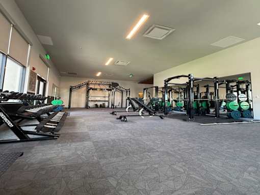 A gym with a variety of equipment including weights and machines.