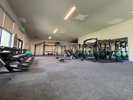 A gym with a variety of equipment including weights and weight racks.