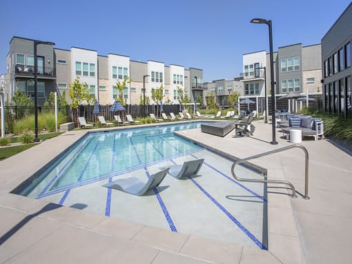 Lounge chairs in pool at The Austin Townhomes