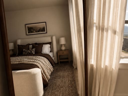 A bedroom with a large bed and a view of the city.
