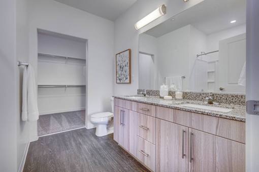 A bathroom with a toilet, sink, and mirror.