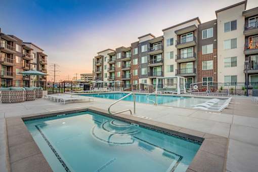 A swimming pool in front of apartment buildings.