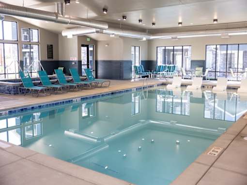 A large indoor swimming pool with lounge chairs.