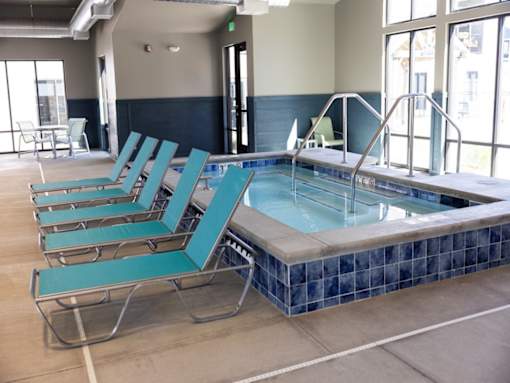 A pool with blue chairs around it.
