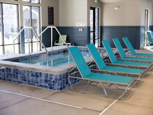 A pool with blue tiles and a metal ladder.