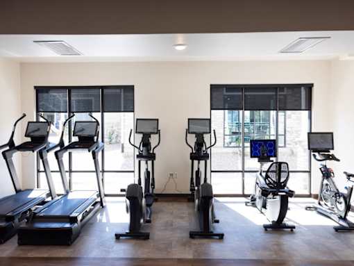 A gym with treadmills, exercise bikes, and elliptical machines.